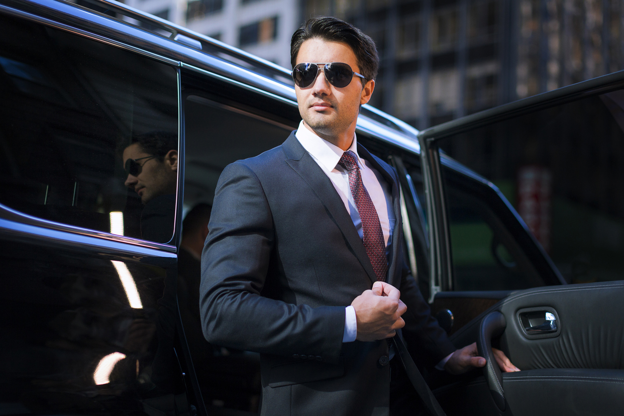 Handsome businessman arriving in executive car